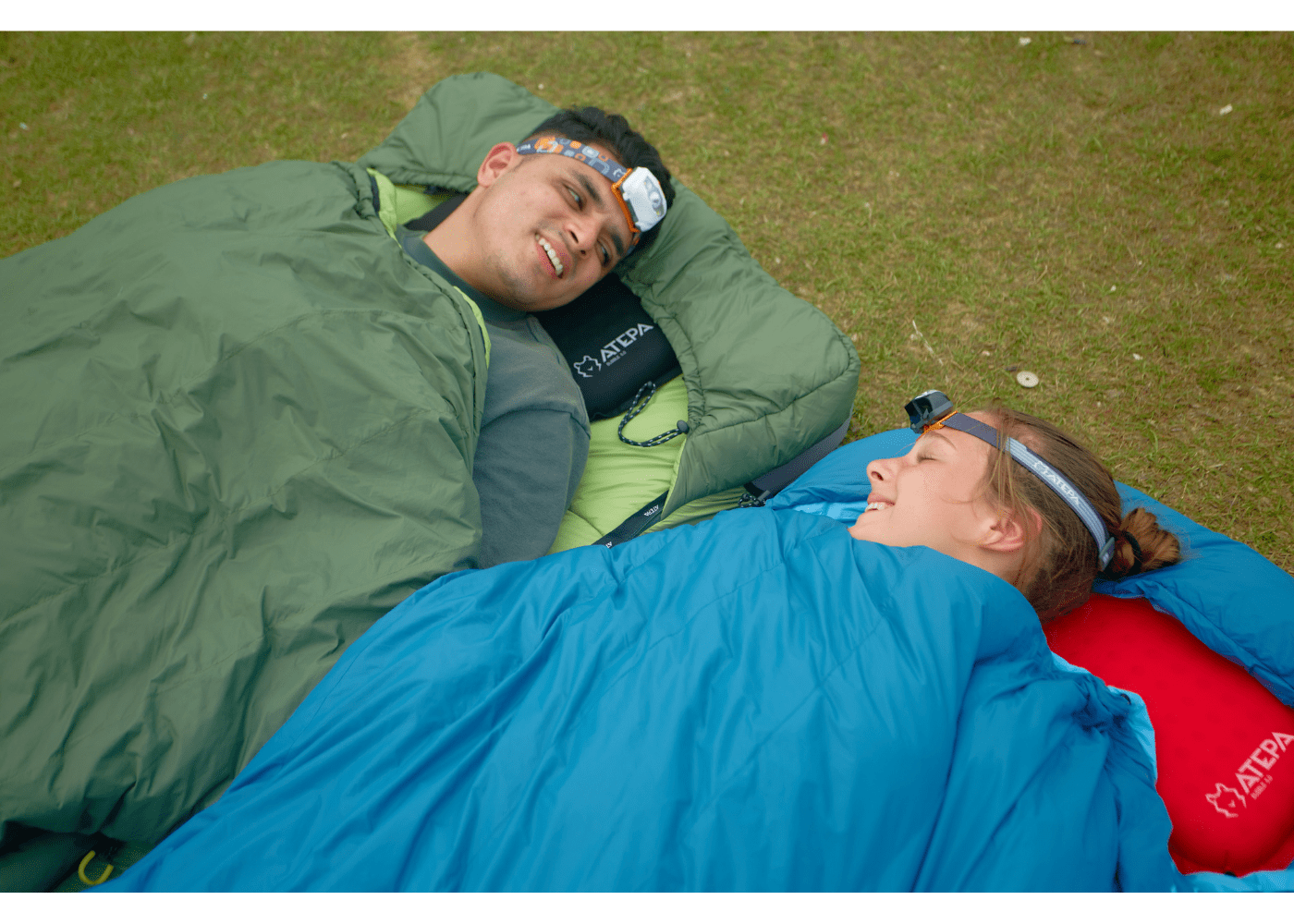 Down sleeping bag displayed on grass for camping and hiking activities